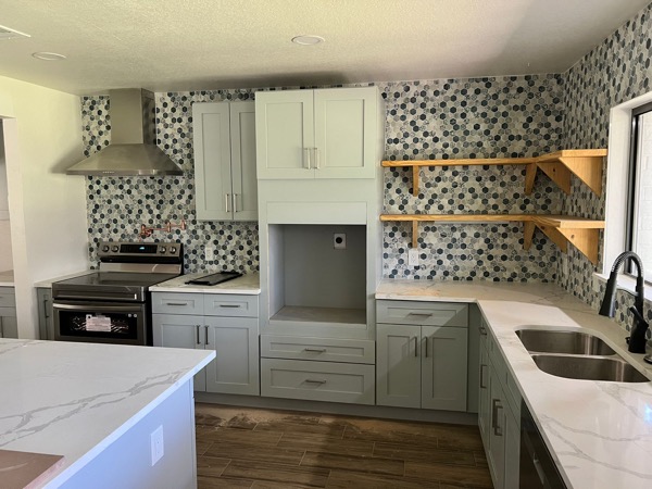 sage green kitchen with quartz by WoodArt Cabinets