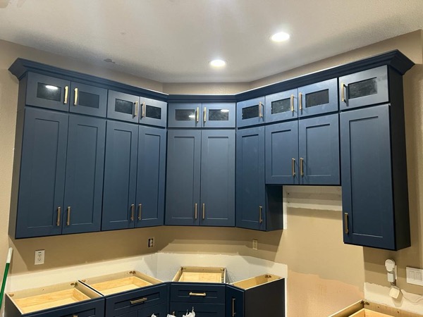 navy blue cabinets with gold handles by WoodArt Cabinets