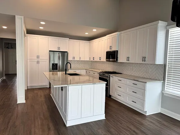 white kitchen with gray backsplash and large island by WoodArt Cabinets San Antonio