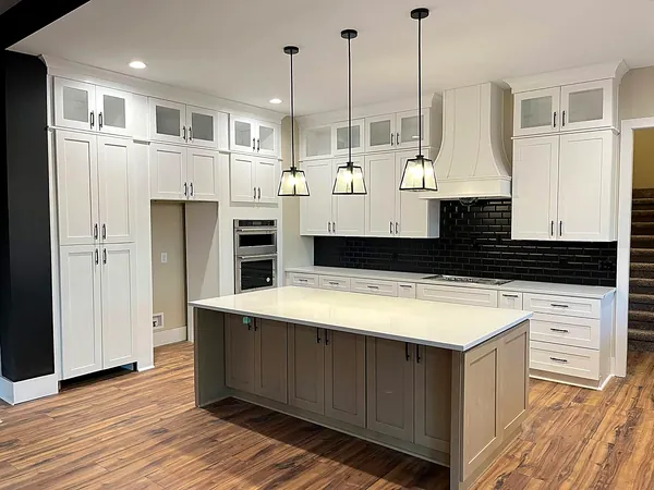 white and navy kitchen with island and pendant lights by WoodArt Cabinets San Antonio