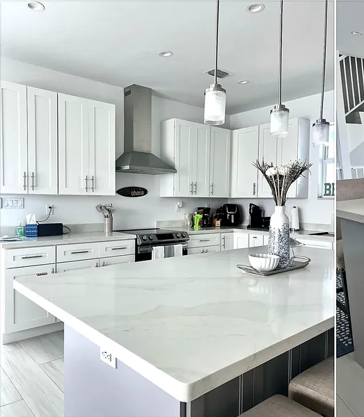 white shaker kitchen with black hood and waterfall island by WoodArt Cabinets San Antonio