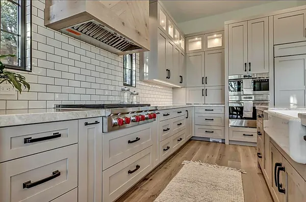 white shaker kitchen with subway tile and professional gas range by WoodArt Cabinets San Antonio