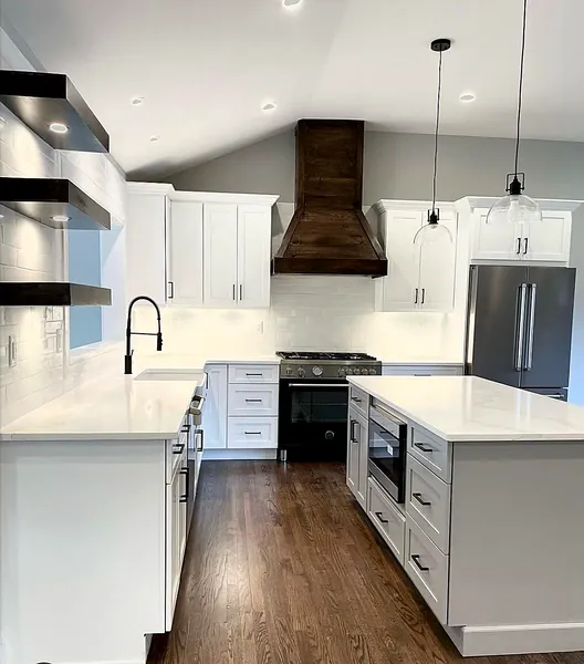 White shaker kitchen with wood range hood and vaulted ceiling by WoodArt Cabinets San Antonio